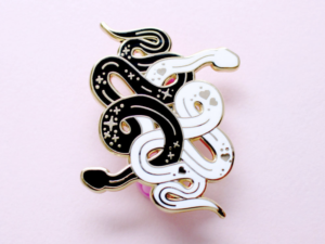 snakes enamel pin on pink background